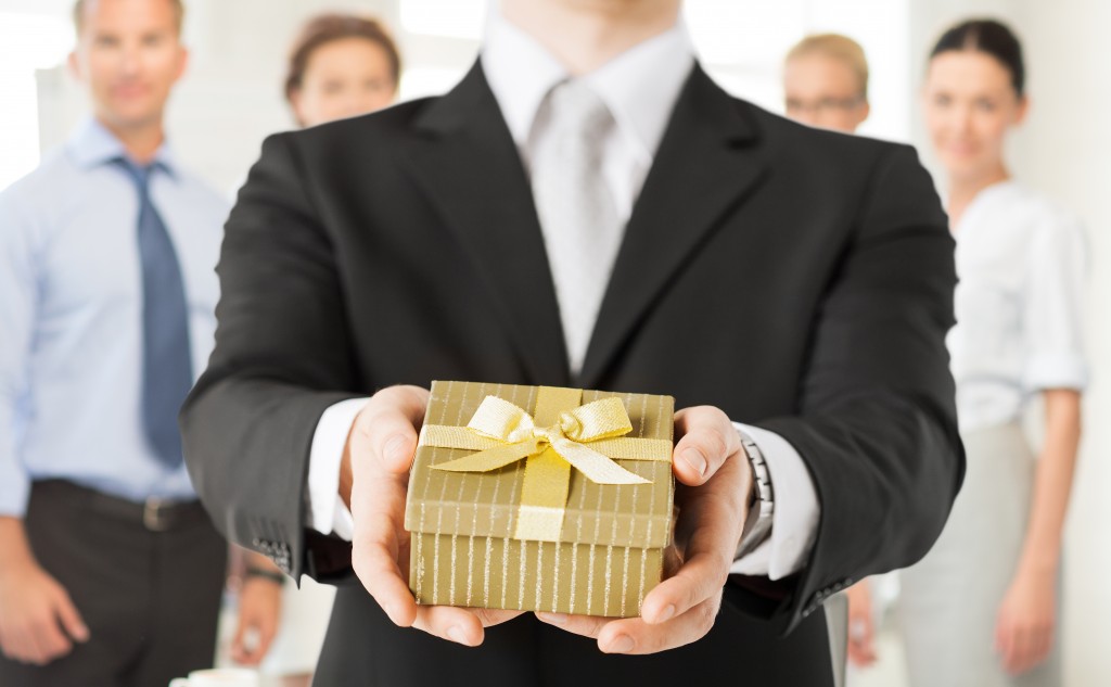 close up of man hands holding gift box in office