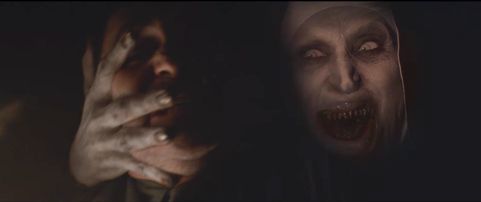 Valak holding a man's face