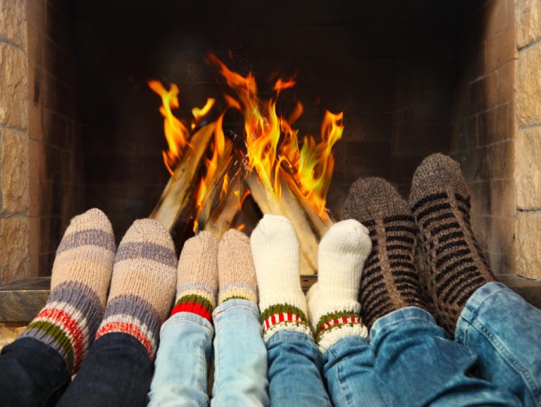 pairs of feet in front of a fireplace